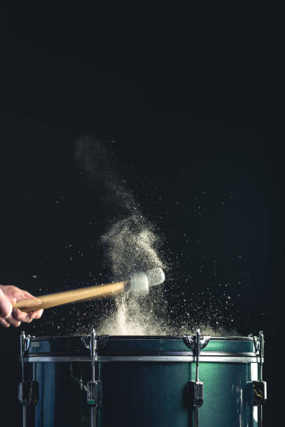 istock A man plays a musical percussion instrument with sticks on a dark background. 1482886079