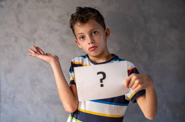 istock A boy is holding a card with a question mark. 1482886268