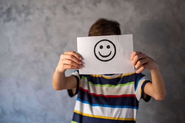 istock the boy is holding a paper with a smiley face 1482886437