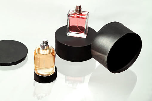 Two Black perfume bottles on a black background. Mockup of black perfume bottle