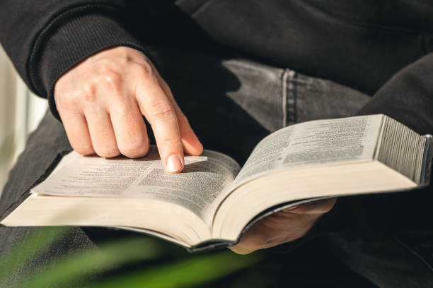 istock Open book Bible in male hands, close-up. 1482889119