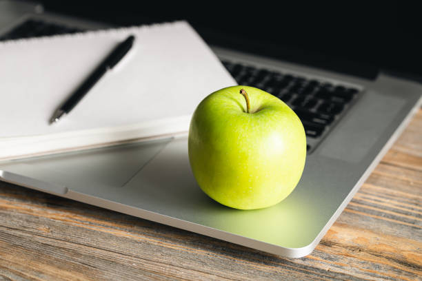istock Apple near laptop at workplace, healthy snack. 1482890193
