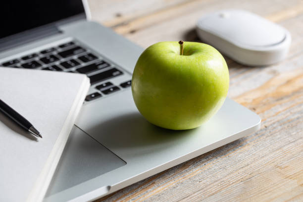 istock Apple near laptop at workplace, healthy snack. 1482890199
