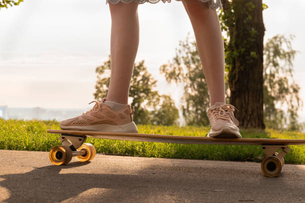 istock Crop faceless woman standing on longboard against summer sky 1482891555