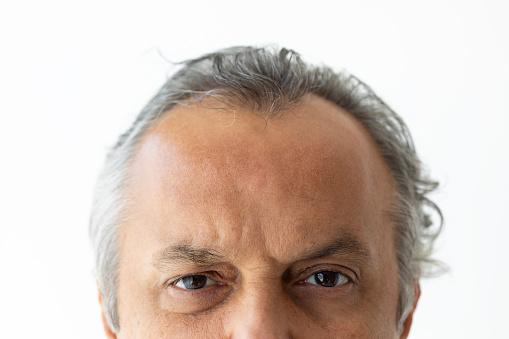 Close-up portrait of a mid adult man with angry expression.