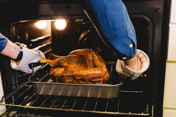 istock Unrecognizable man taking out ready crispy turkey from the oven 1482898549