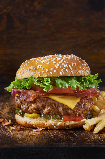 Grilled Juicy PORK and Bacon Cheeseburger with Lettuce, Tomato, Pickles, Ketchup, Mustard and Fries