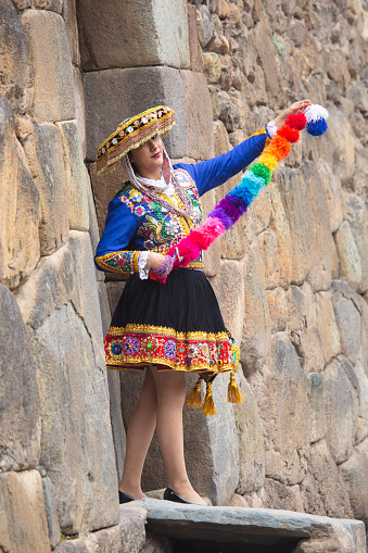 Beautiful girl with traditional dress from Peruvian Andes culture. Young girl in Ollantaytambo city in Incas Sacred Valley in Cusco Peru.