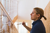 Woman painting the stairs at home