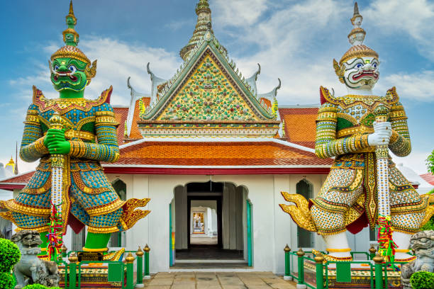 Sculptures of two mythical giant demons, Thotsakan and Sahatsadecha, guarding  Wat Arun temple in Bangkok, Thailand.