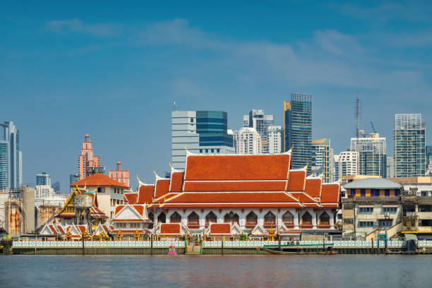 Wat Khlong Toei Nok temple and the skyline of Bangkok, Thailand.
