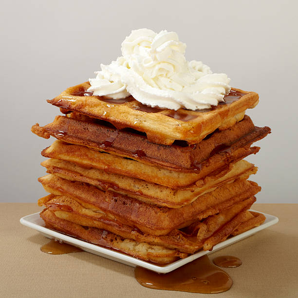 istock Large stack of belgian waffles with syrup and whipped cream 148291035