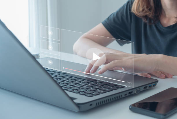 istock streaming online, watching video on internet, live concert, show or tutorial. Person watching online movie or TV series on laptop computer screen. Concept about subscription based live digital stream. 1482912143