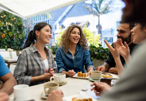 Friends looking very happy talking at a cafe