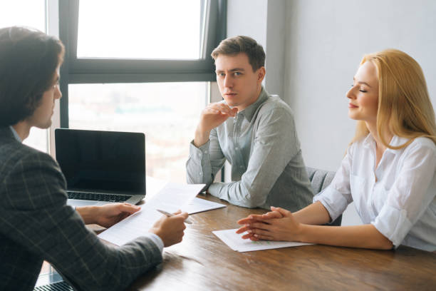 istock Side view of confident business partners discussing contract terms and project strategy at meeting in boardroom, sitting at table by window 1482945136