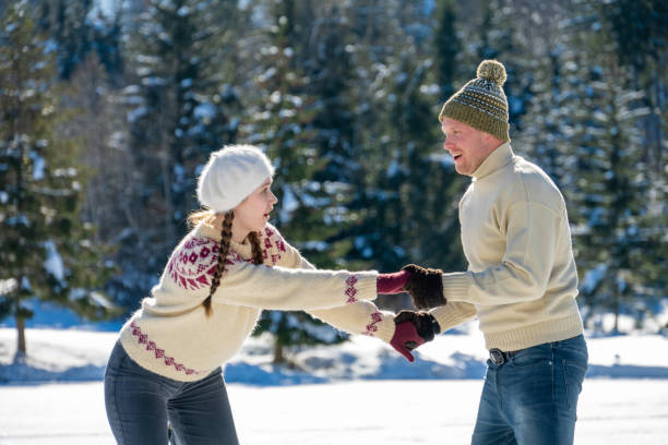 istock Couple holding hands while ice skating on lake 1482947426
