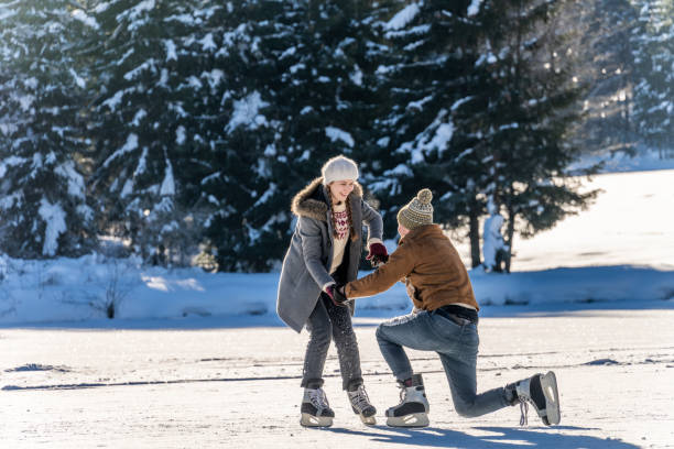istock Woman helping fallen man to stand up while ice skating 1482947428