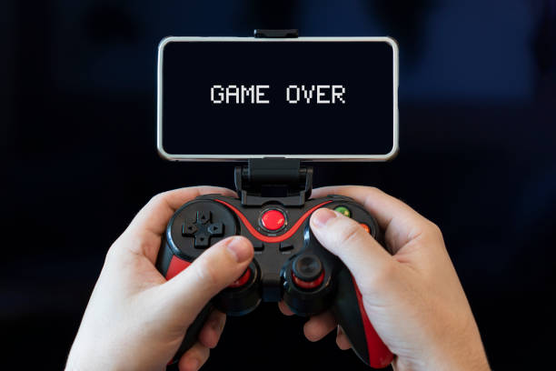 istock a gamer plays on a smartphone. Hands with joystick with phone on black background 1482947479