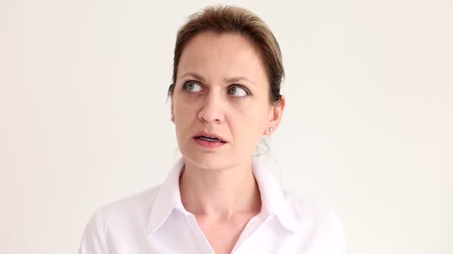Suspicious woman turns head to sides opening eyes broadly