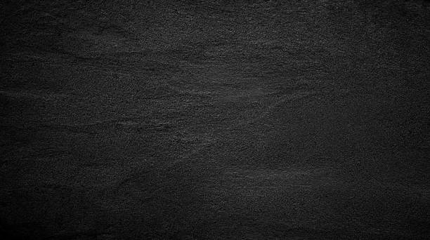 Black or dark gray rough grainy stone or sand texture background stock photo