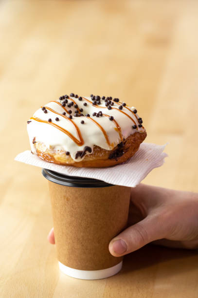 istock Appetizing donut and coffee in male hands, close-up. 1482951803