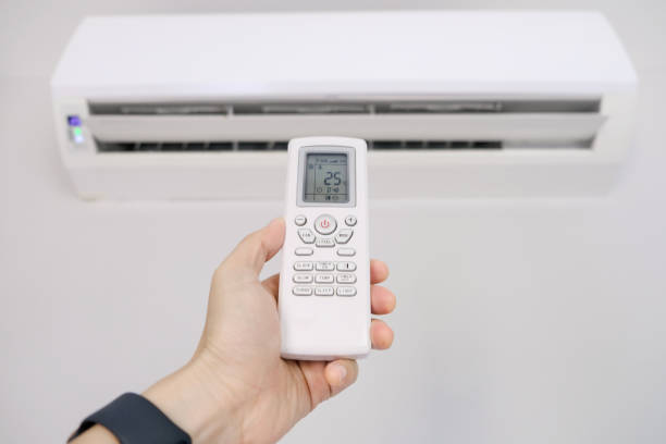 istock Man's hand using remote control open The air conditioner is cooled to 25 degrees Celsius in his bedroom. Health concepts and energy savings 1482959035