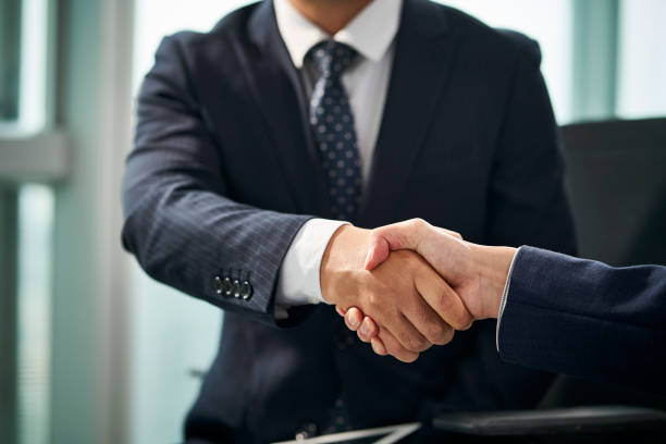 istock two asian businessmen shaking hands in office 1482966273