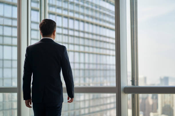 istock asian businessman standing by window looking at view 1482966307