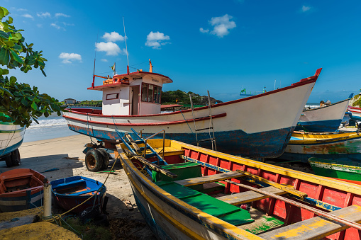 Local fishing boats on Matadeiro beach and ocean in sunny day. Colorful boats on beach in Florianopolis
