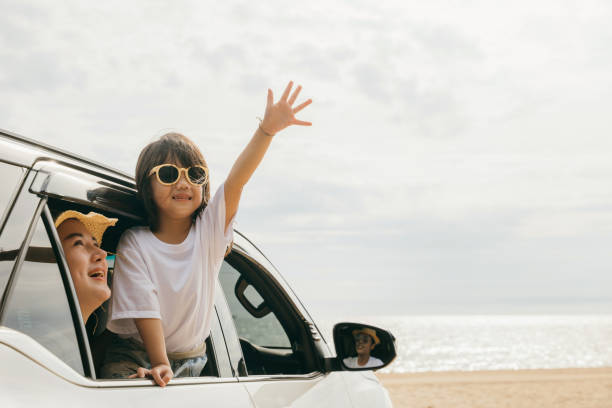 istock Father, mother and child smiling having fun sitting in compact white car windows raise hand wave bye bye 1482967165