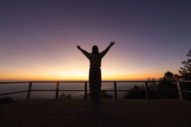 silhouette einer frau, die ihre hände in anbetung hebt, frau, die für gott betet, hintergrund des konzepts der christlichen religion. - heaven women sunrise inspiration stock-fotos und bilder