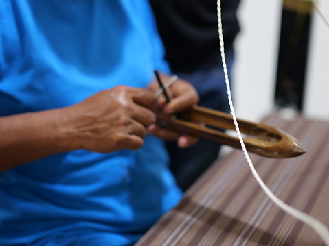 Selective focus traditional weaver is preparing yarn. Preparing the loom before starting to make woven ikat