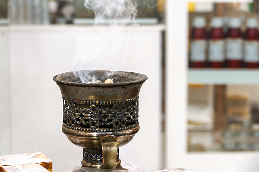 A massive bronze bowl with smoking frankincense in a shop in the old quarter of Muscat, Oman