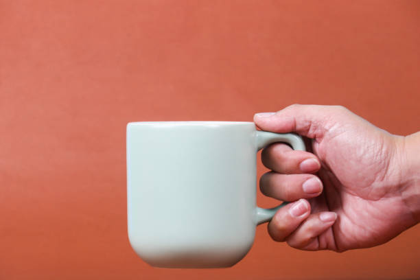 istock hand holding coffee cup with copy space for design wood grain vintage background 1482984518