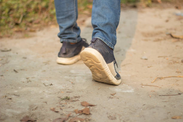 istock Two boots with two feet and some grass behind 1482985759