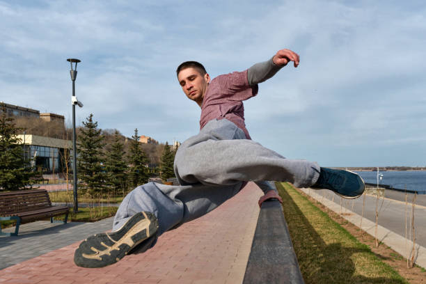 Sport man practicing parkour in urban space. Parkour athlete jumping over the railing. Active lifestyle. Outdoor acrobatics