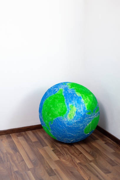 istock Eco problem. Planet earth in the corner of the room. Surrealism. 1482987407