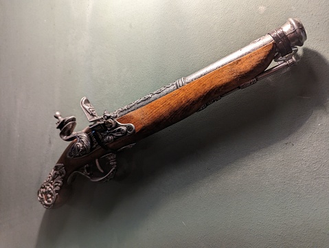 A flintlock pistol with the barrel displayed in a vintage-style atmosphere