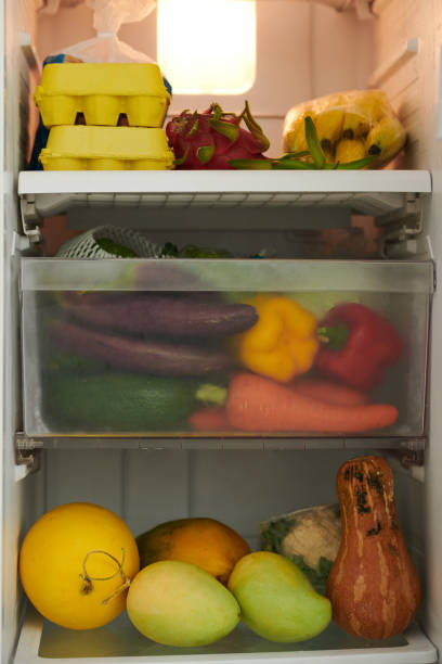 geöffneter kühlschrank mit lebensmitteln - refrigerator healthy eating mango fruit stock-fotos und bilder