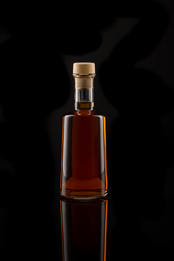 Bottle of wine vinegar isolated in front of a black background