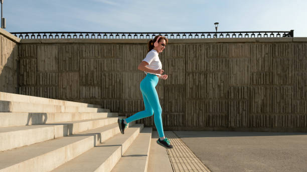istock Young woman jogging on city streets 1482996555