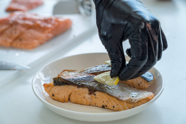 Fried sea fish. Preparation on open fire. Salmon steaks served with lemon wedges.