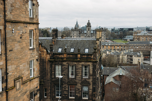 A cityscape photograph of the City of Edinburgh, Scotland, showcasing Edinburgh Castle and the Salisbury Crags on a clear day in Autumn.