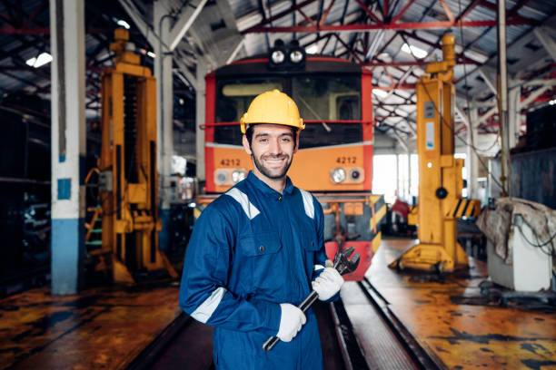 Portrait of man engineer standing with crossed arms and looking camera in train factory. stock photo
