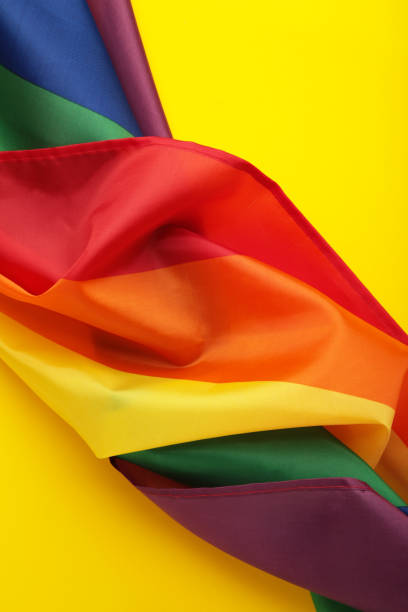 istock The rainbow flag (LGBT) on yellow background. Vertical photo. 1482998433