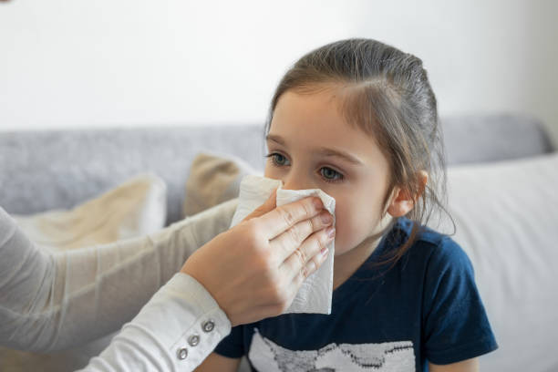istock Mom helping a daughter blow her nose 1482998656