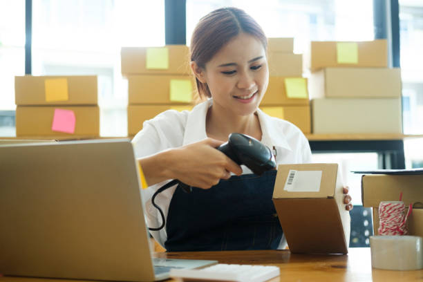 istock Female online business owner scanning parcel barcode tag. 1482998664