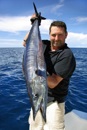 Lucky  fisherman holding a beautiful wahoo fish. This fish can swim up to 60 mph