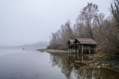 stilt houses on the lake on a foggy day.