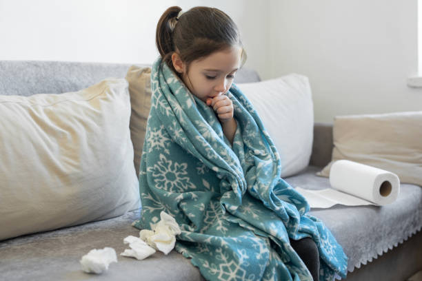 istock Sick young girl with flu on the sofa sneezing 1483000732